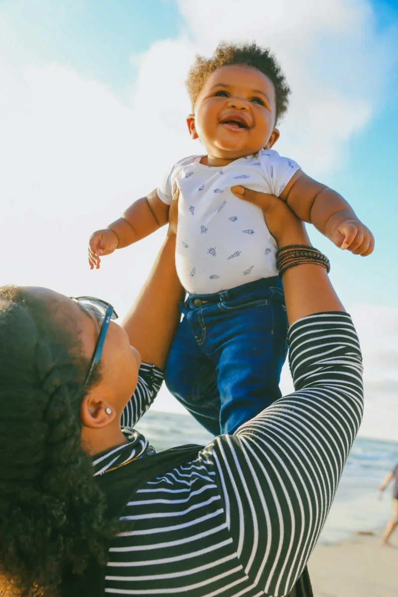 A parent lifting a young child